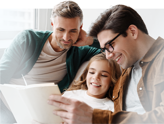 same sex couple reading with young girl